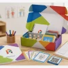 The Play Therapy Box is open on a table, showing a printed manual, cards, tools, a QR code, and a simple follow-up form, appearing as a “training system” rather than a single game.